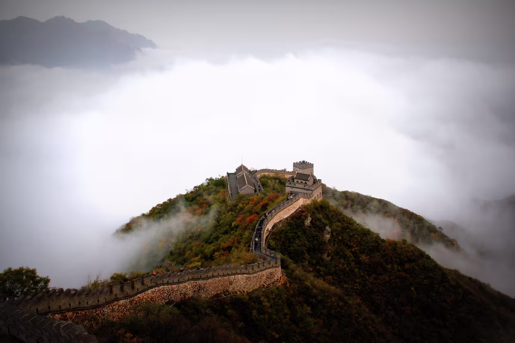 China Majestic aerial shot of the Great Wall of China surrounded by mist and mountains