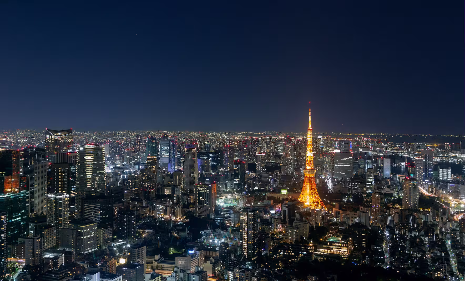 Japan A breathtaking aerial view of Tokyo's skyline, featuring the illuminated Tokyo Tower at night